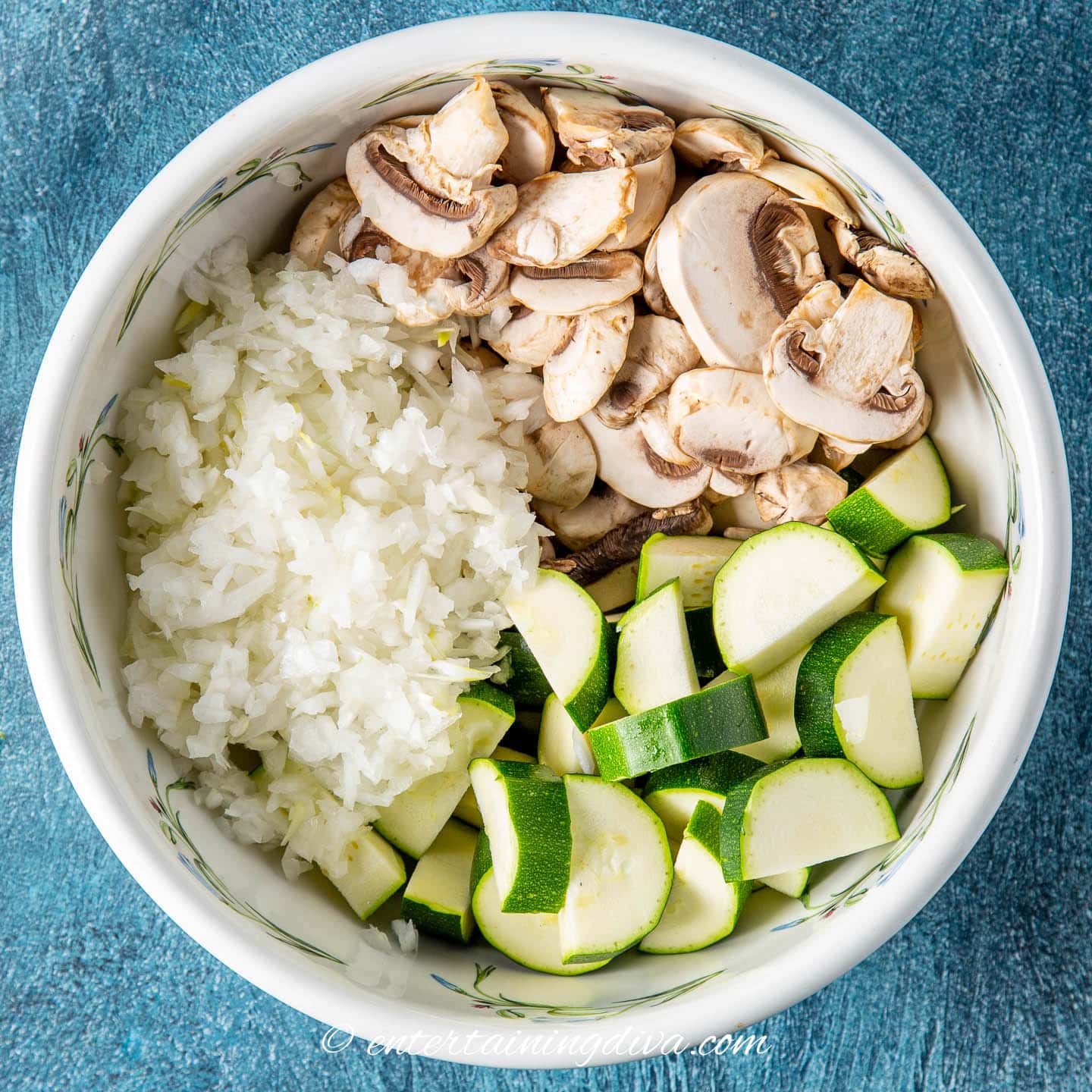 diced onion, chopped mushrooms and sliced zucchini in a bowl