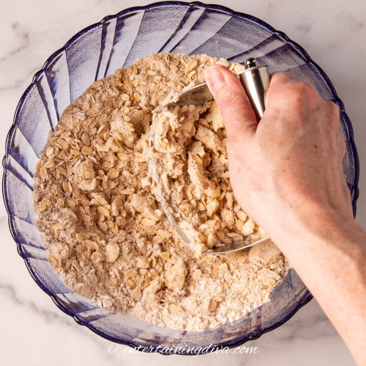 pastry knife cutting butter into rolled oats mixture