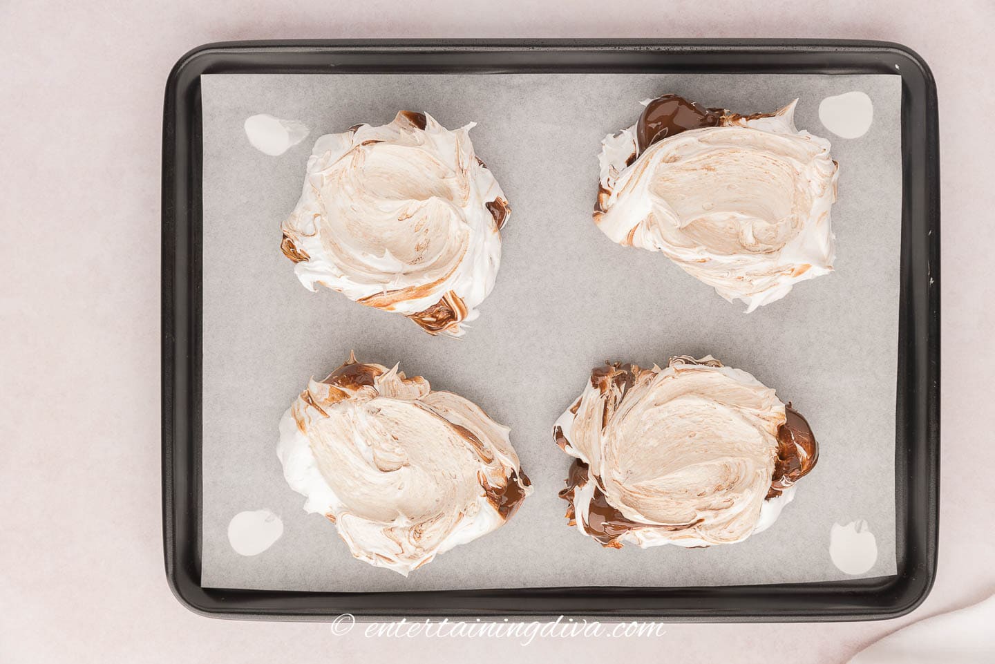 Dollops of meringue mixture on a baking sheet 