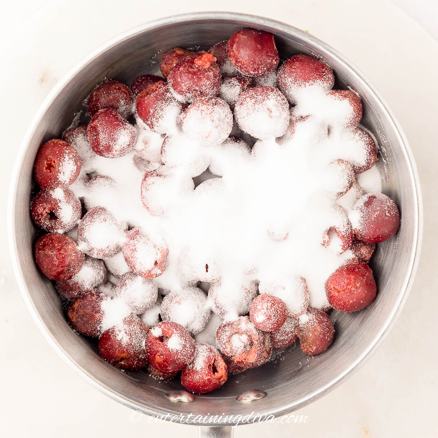 Frozen cherries and sugar in a saucepan