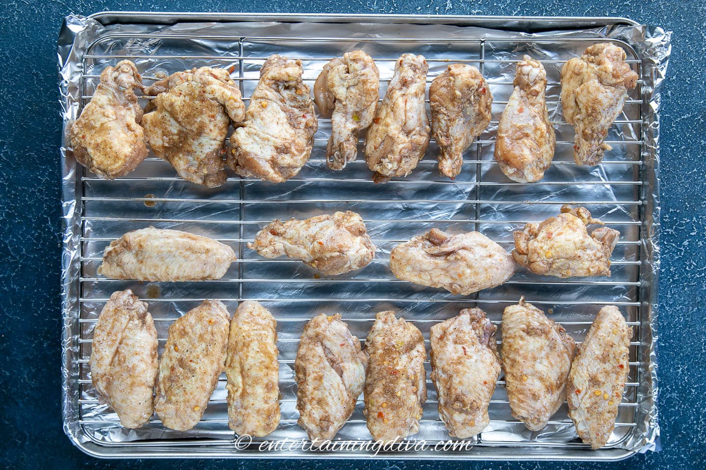 marinated wings on a baking sheet with a baking rack