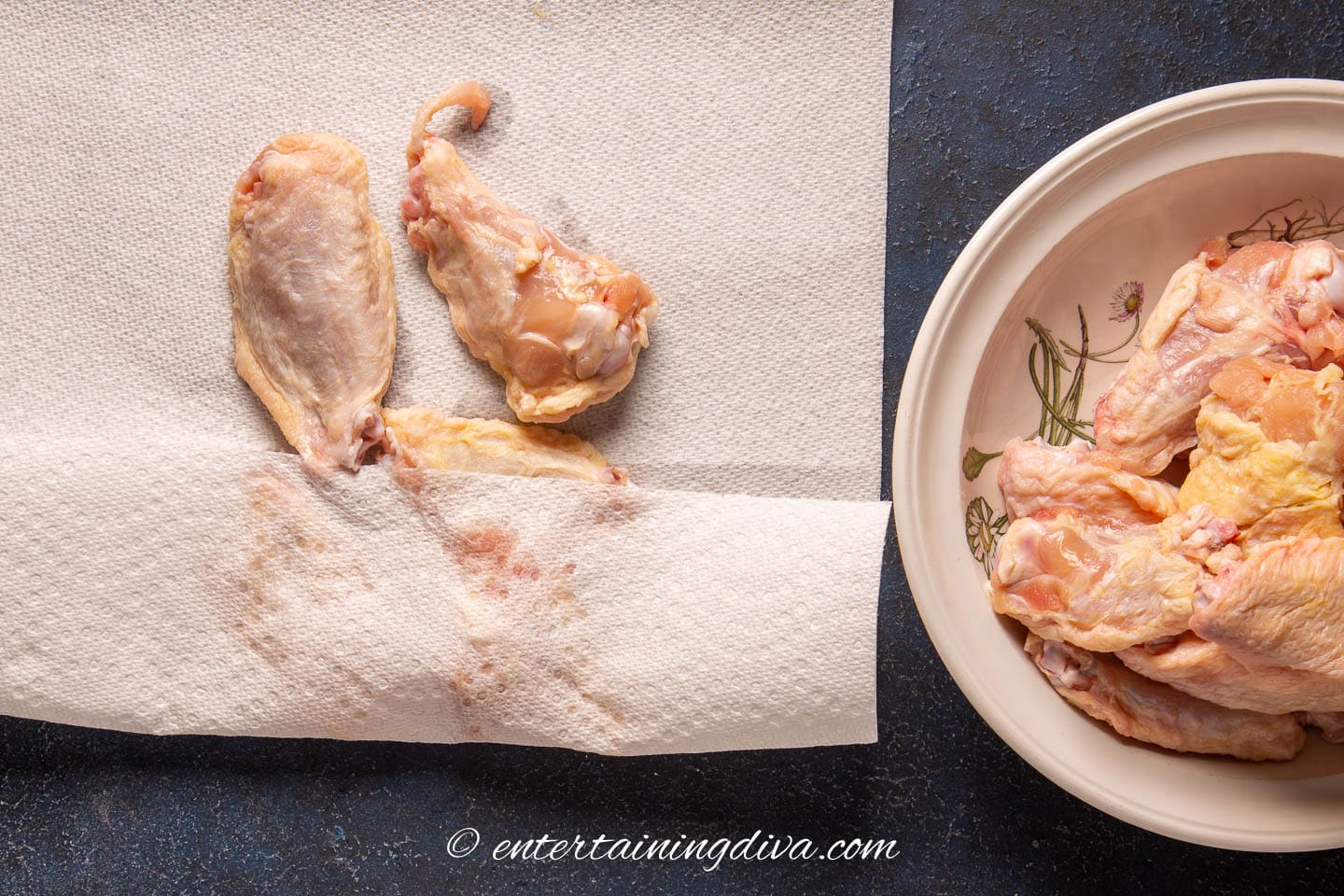 chicken wings being dried with paper towel