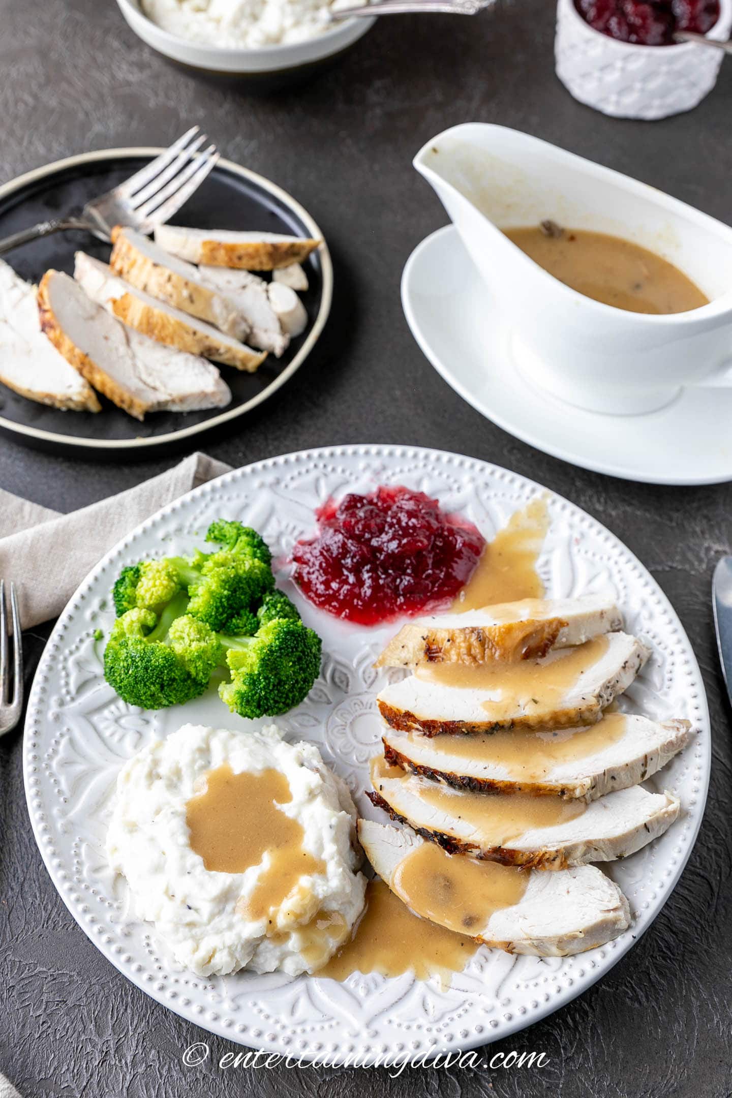 Plate with turkey, cranberry sauce, broccoli, and mashed potatoes with turkey gravy