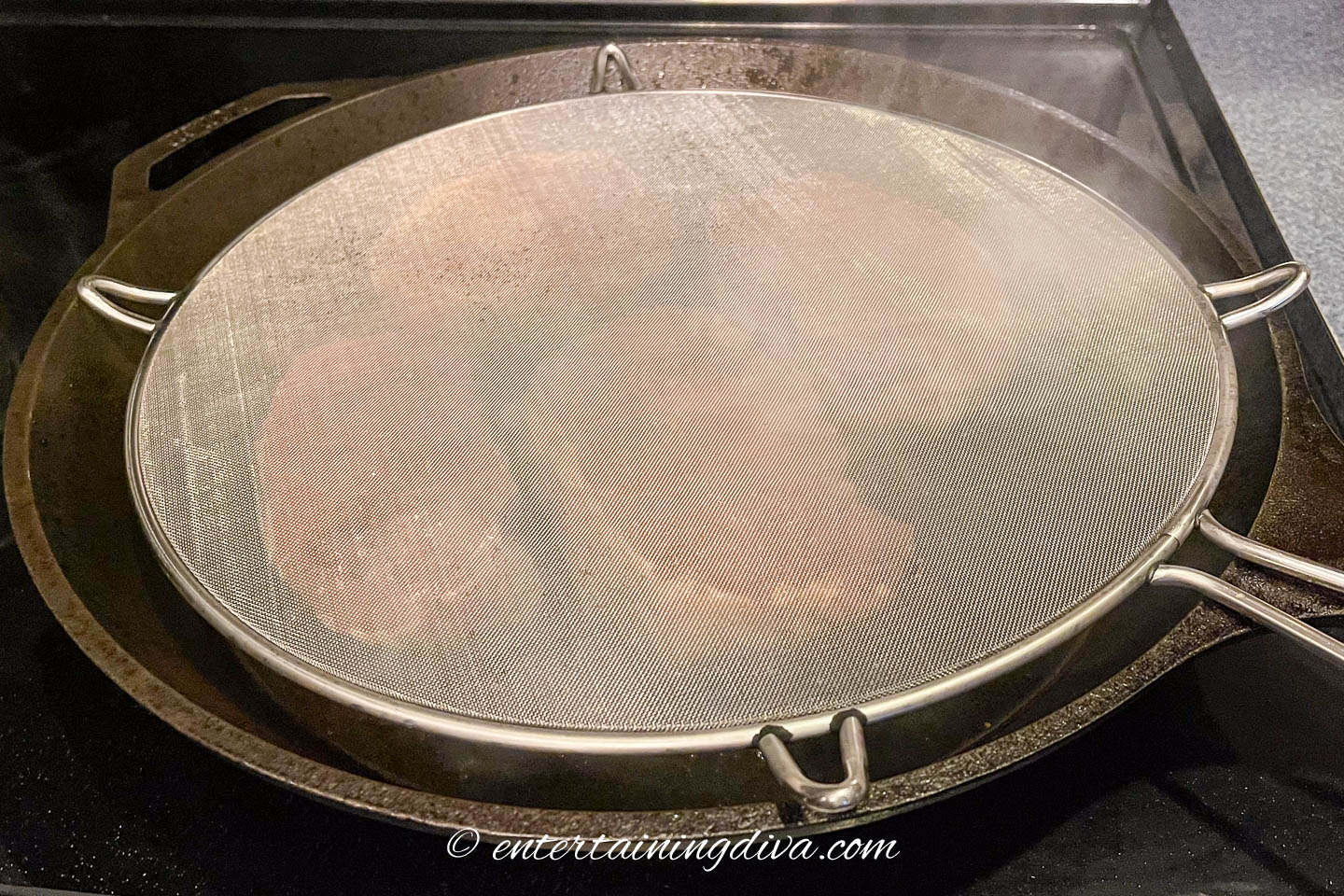 Splatter screen over a frying pan with pork chops
