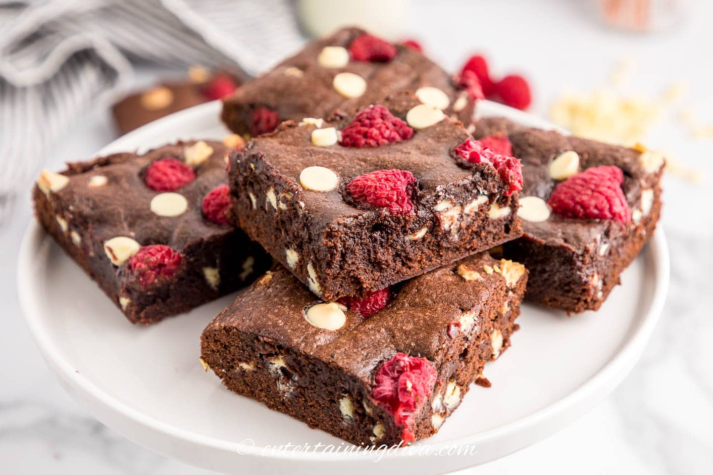 A stack of white chocolate raspberry brownies on a plate