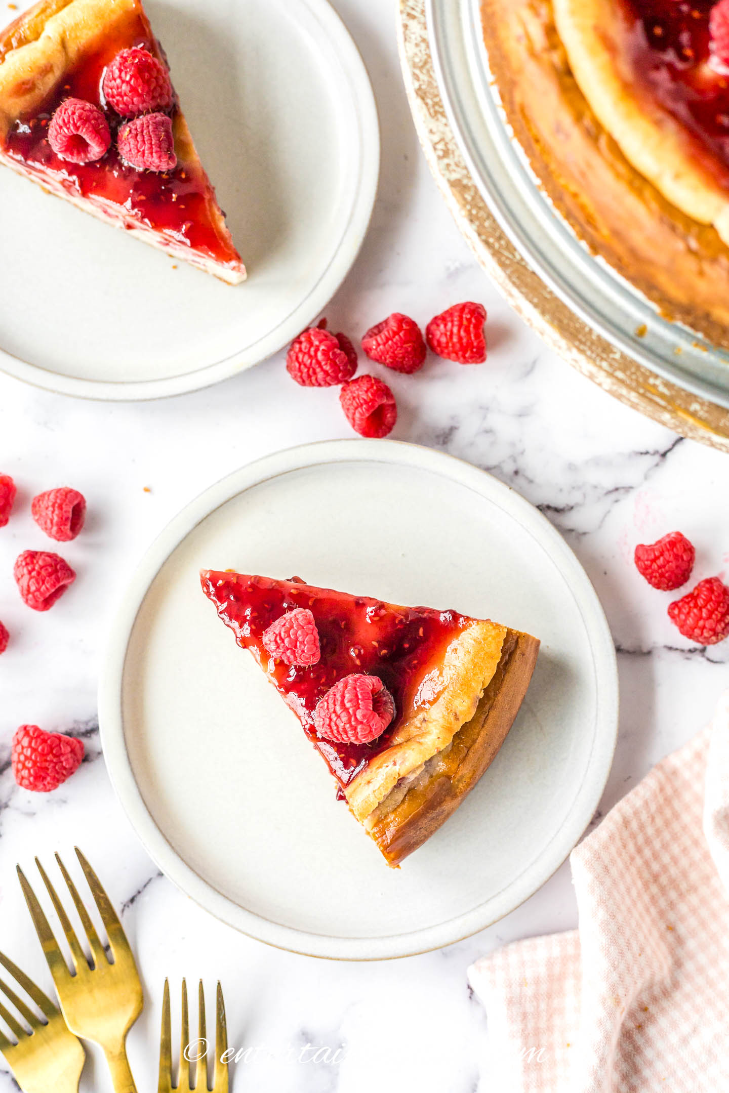 Two pieces of baked raspberry cheesecake on plates