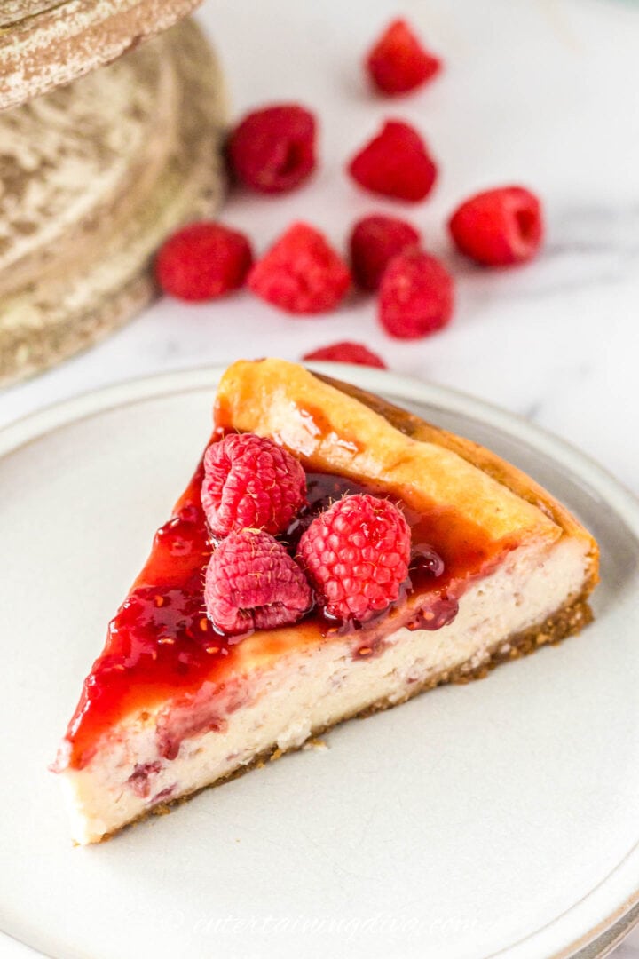 A slice of baked raspberry cheesecake on a plate