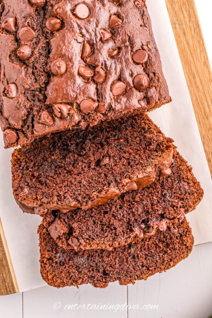 sliced chocolate zucchini bread with chocolate chips on a cutting board