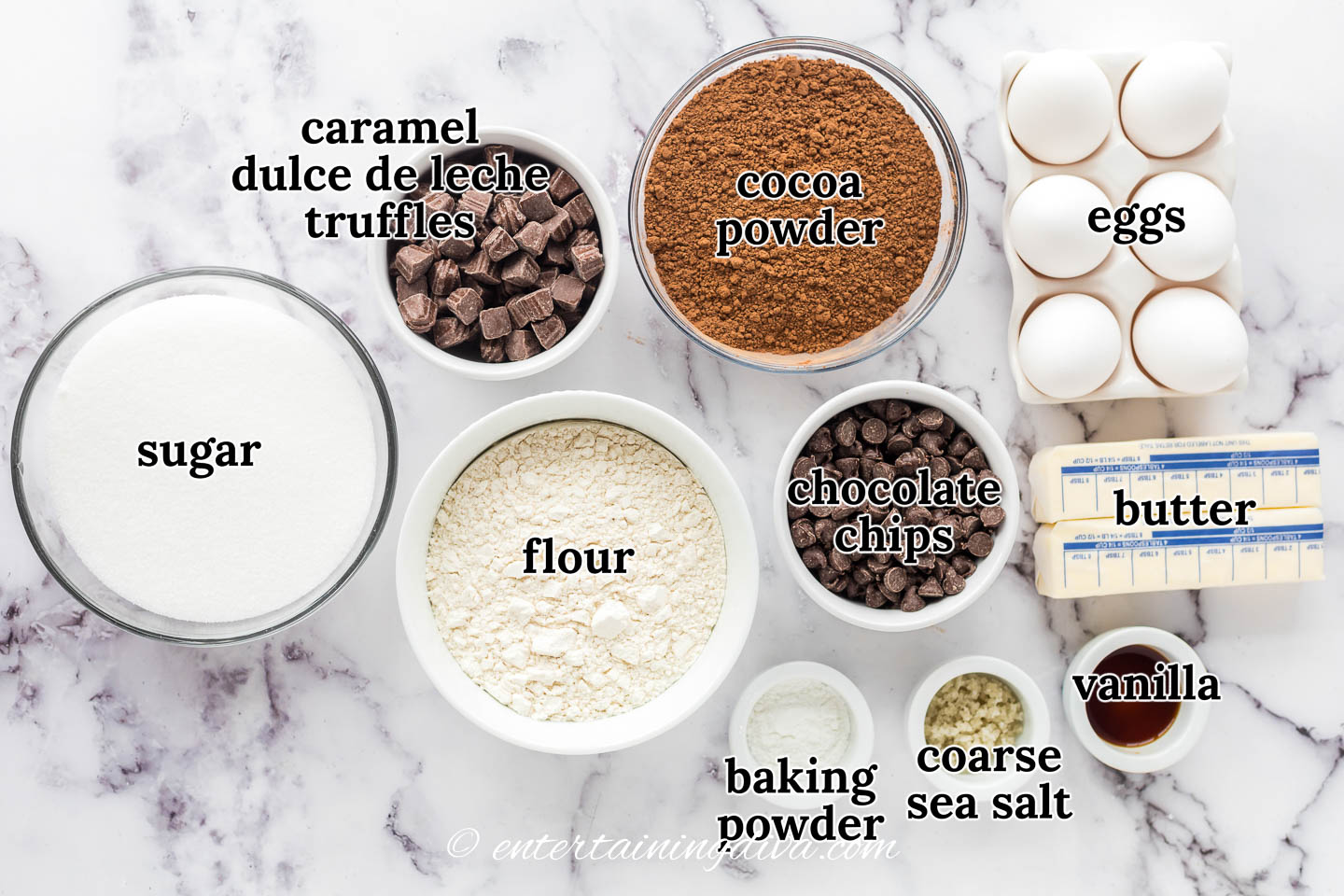 Ingredients for salted dulce de leche brownies - caramel dulce de leche truffles, cocoa powder, chocolate chips, eggs, butter, sugar, flour, baking powder, vanilla, coarse sea salt