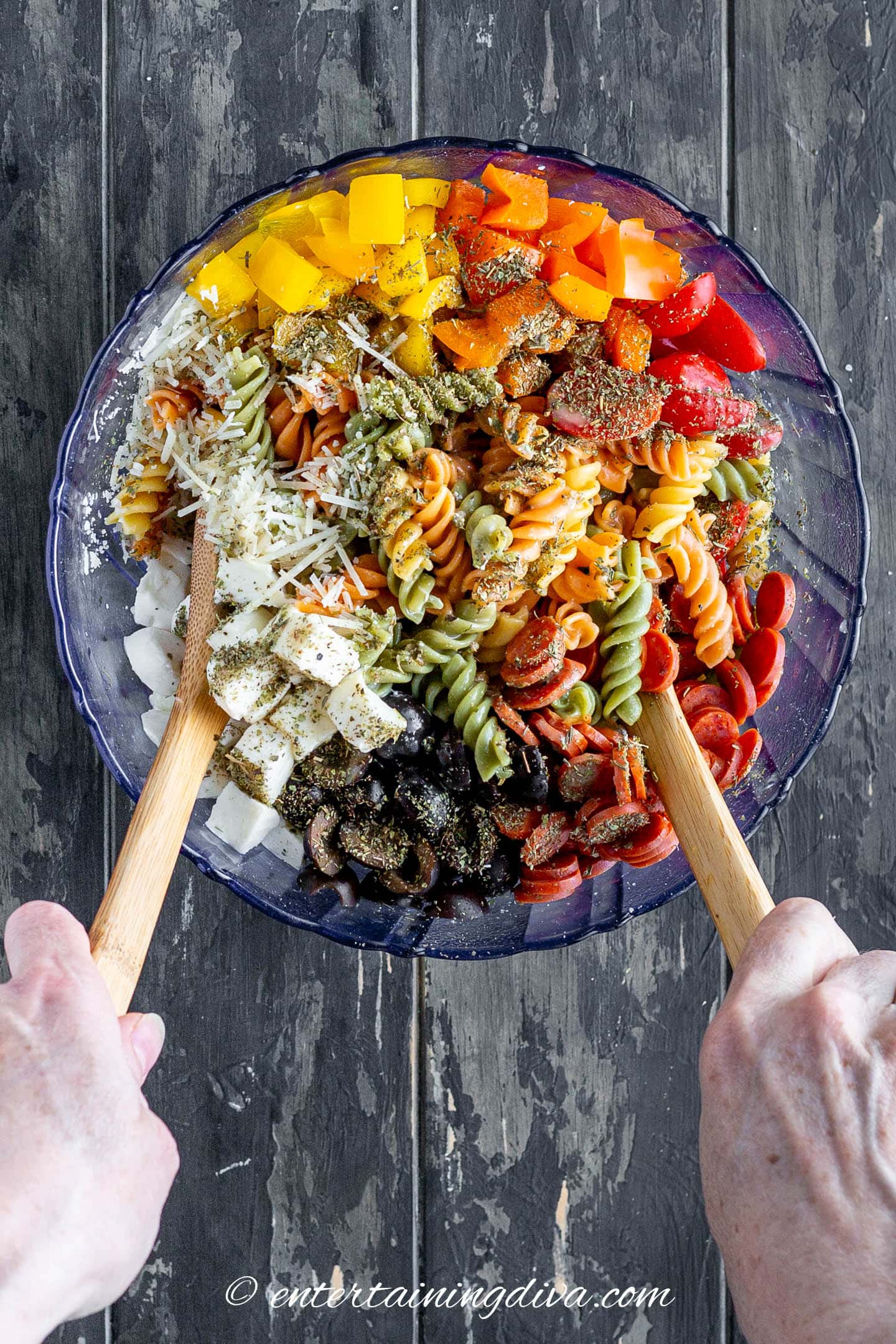 Italian pasta salad being tossed in a bowl
