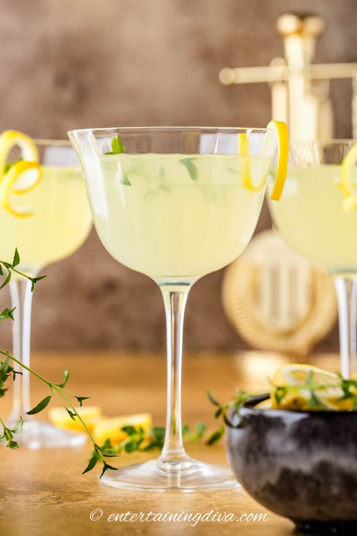 Limoncello martini with thyme and lemon twist garnish.