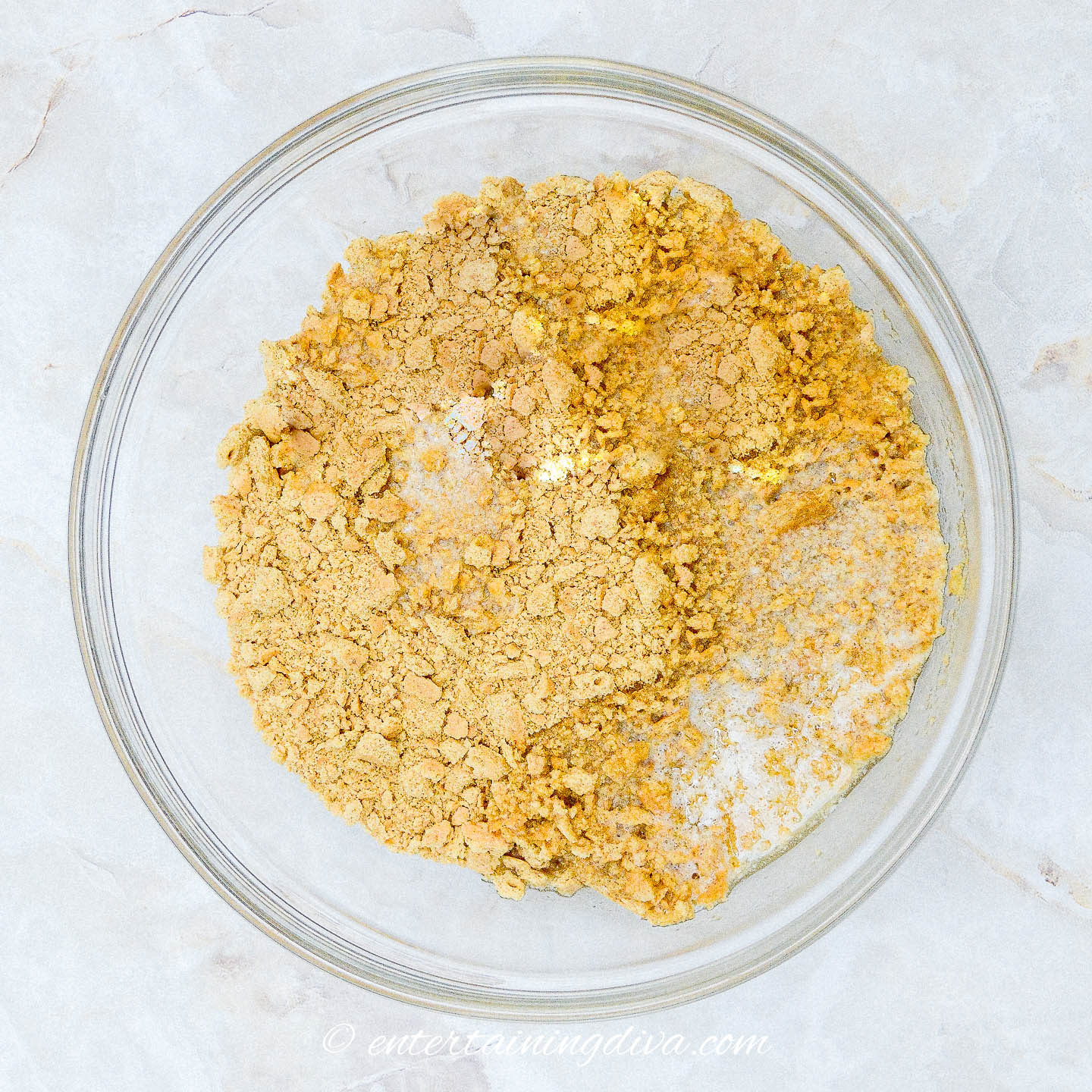 graham cracker crumbs and melted butter in a glass bowl