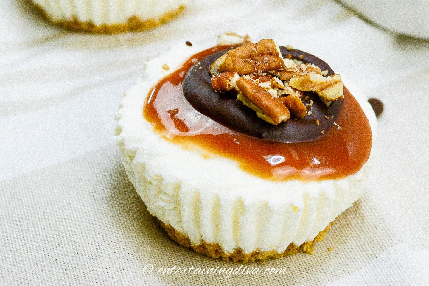 Mini cheesecakes topped with caramel, chocolate and pecans.