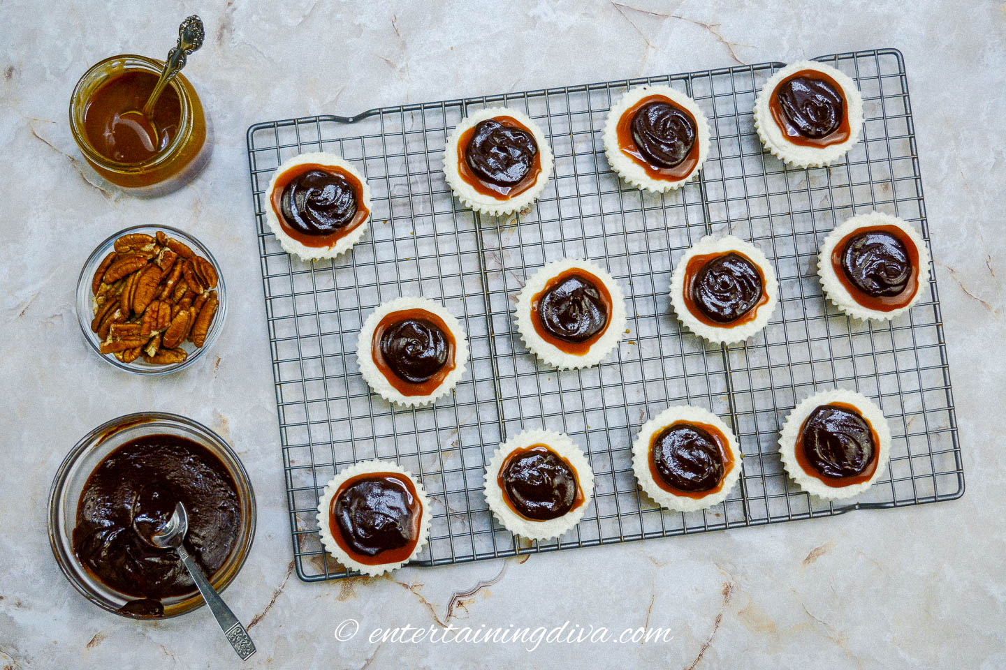 A rack of mini cheesecakes with caramel and chocolate on top