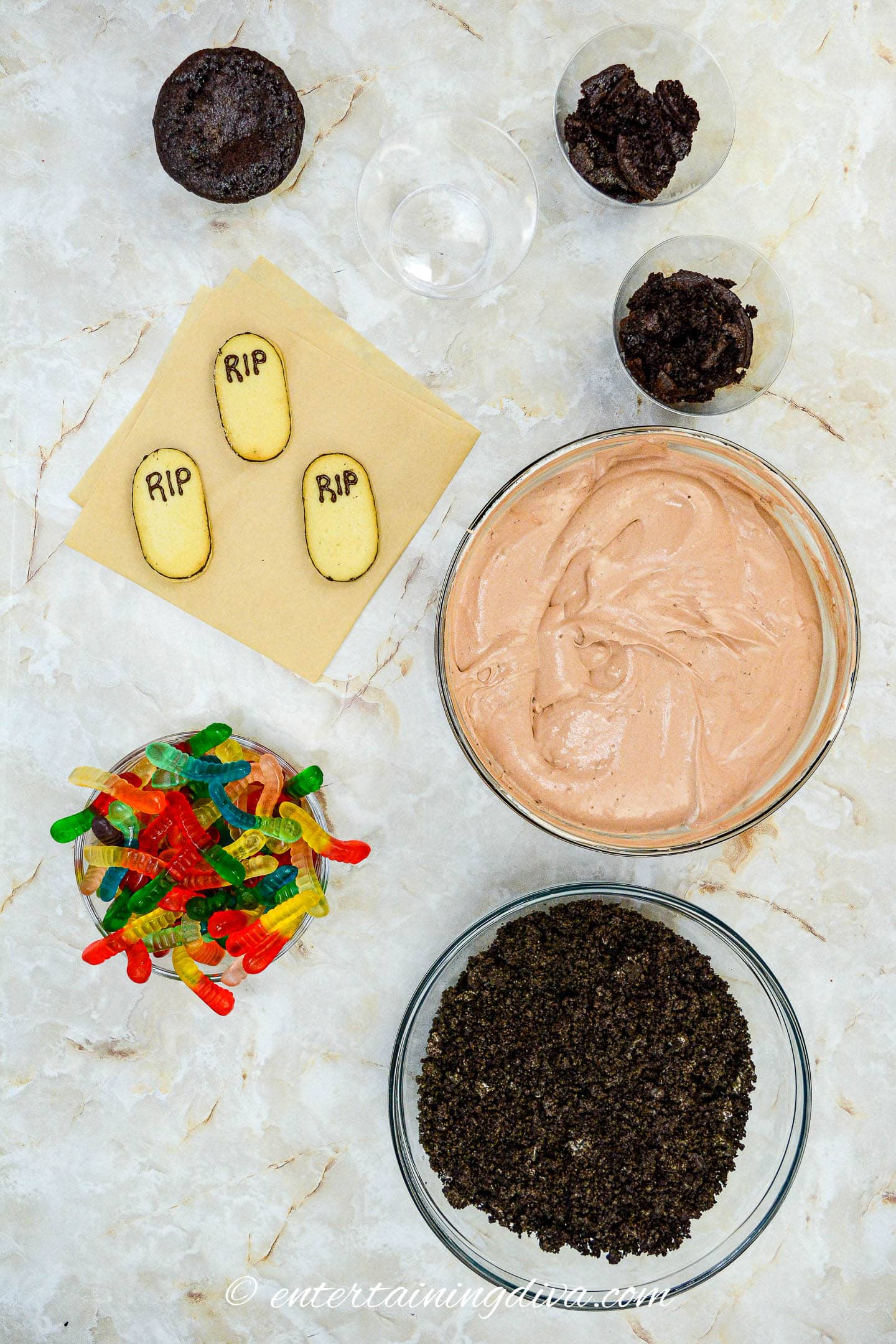 The ingredients for an easy Halloween Graveyard Dirt Pudding Cups dessert are laid out on a table.