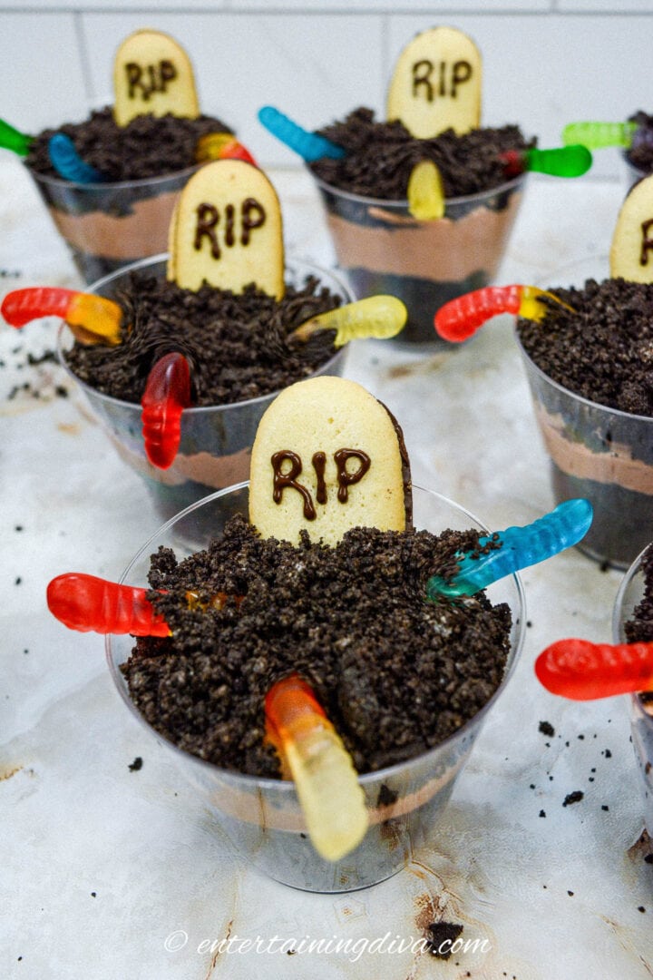 A group of Halloween pudding cups with RIP cookie tombstones, resembling a mini raveyard.
