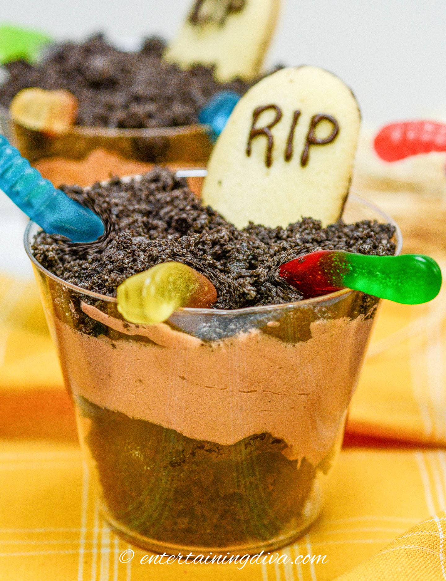 Halloween graveyard pudding cups on an orange tablecloth