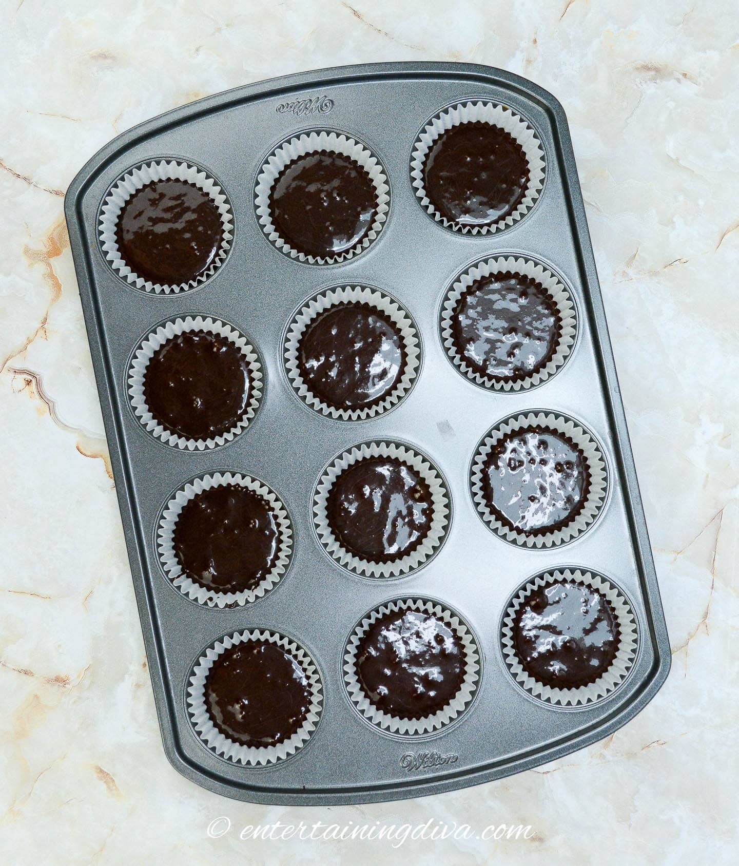 chocolate cupcakes in a muffin tin before baking