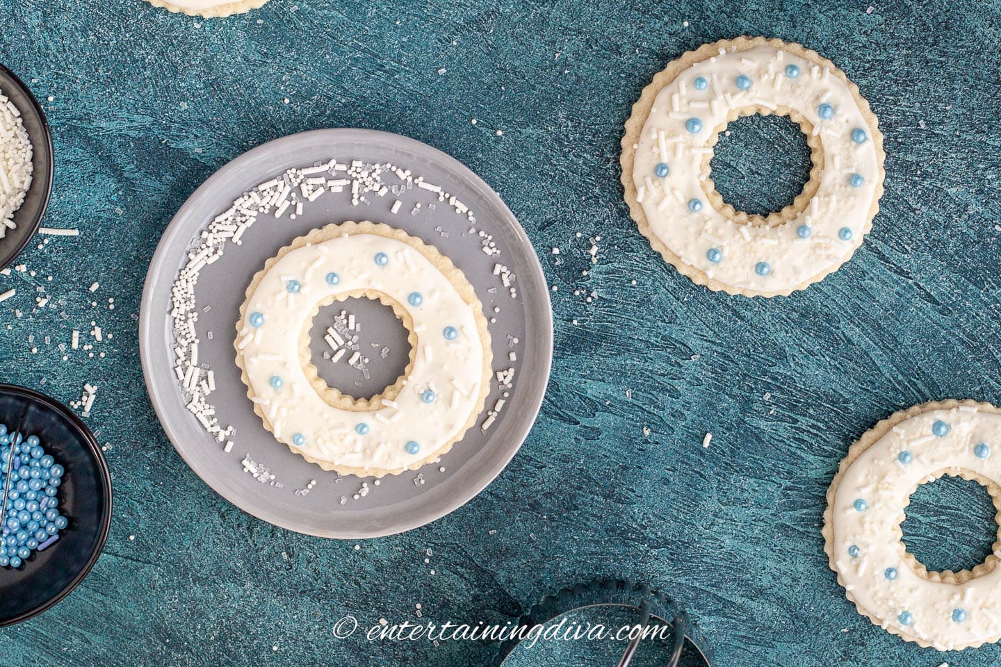 Christmas wreath sugar cookies with blue sprinkles.