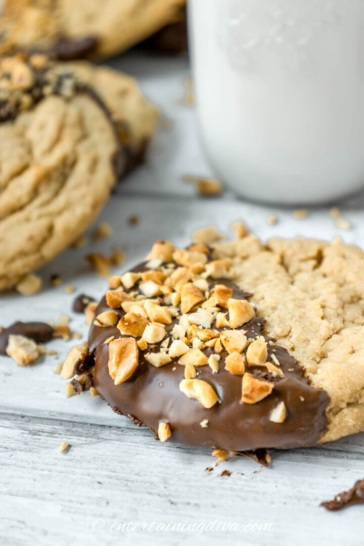 Chocolate dipped peanut butter cookies with a glass of milk.