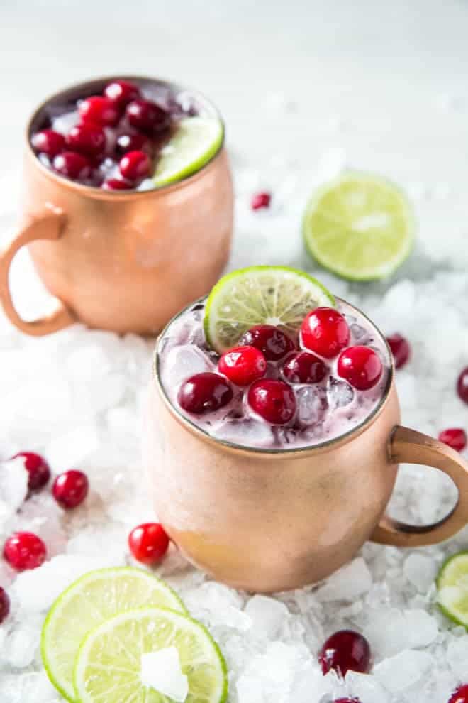 Two cranberry Moscow mules in copper mugs