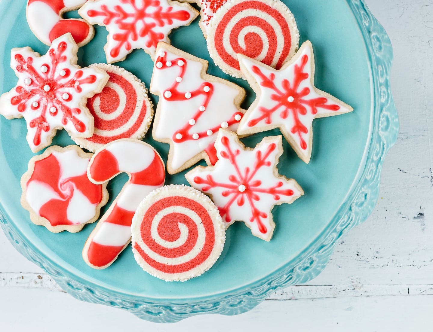 A plate of Christmas sugar cookies all decorated in red and white royal icing
