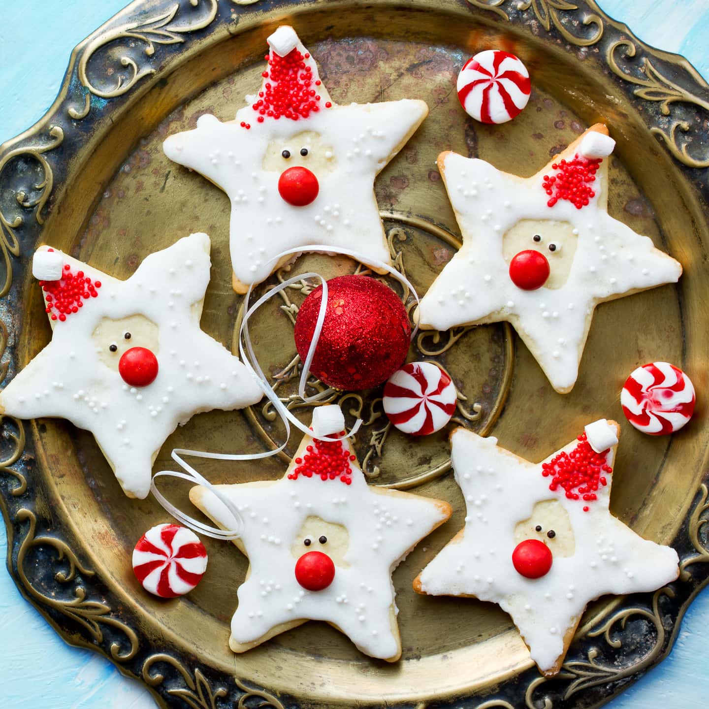 Star-shaped Christmas sugar cookies decorated like Santa Claus.