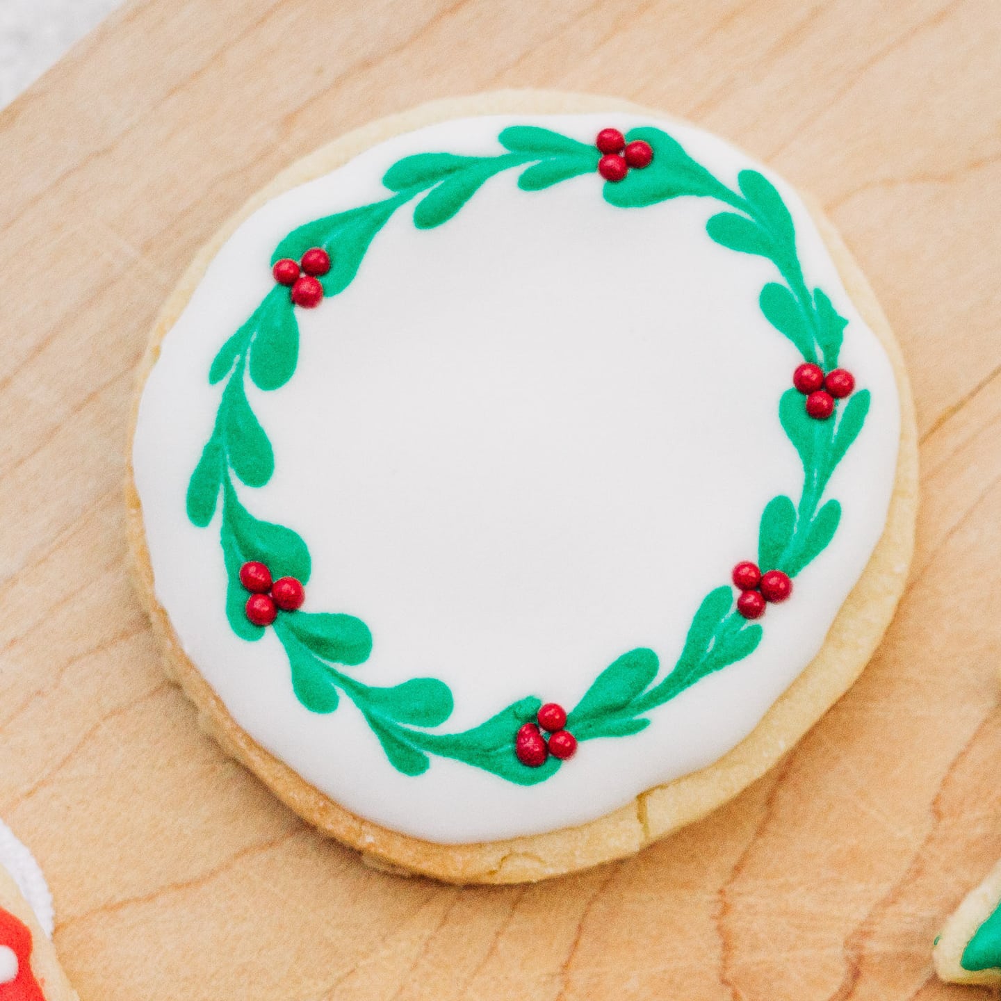 Round sugar cookie decorated as a Christmas wreath