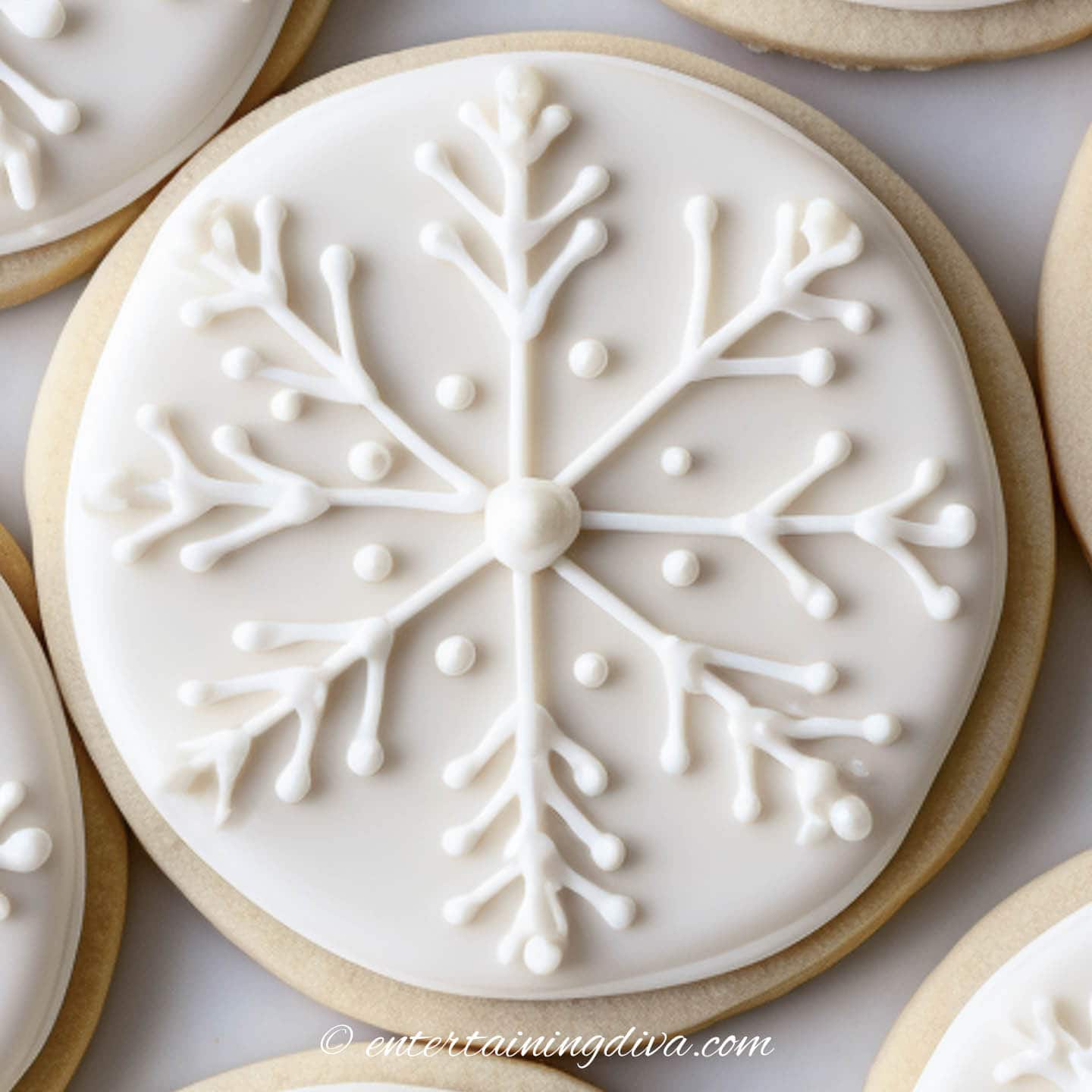 White snowflake Christmas sugar cookie design on a round cookie