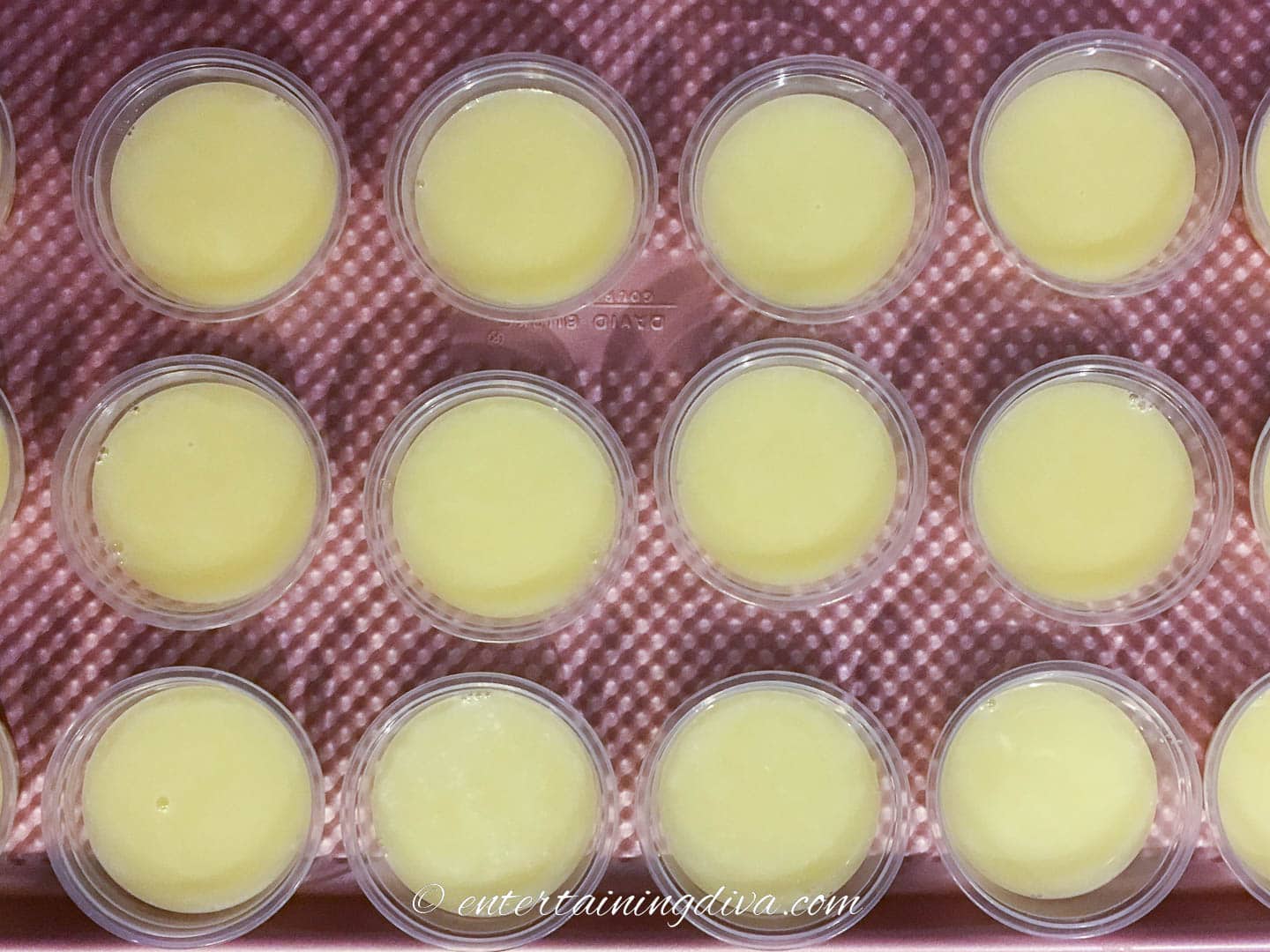 Piña colada jello shots in Jello shot cups on a cookie sheet