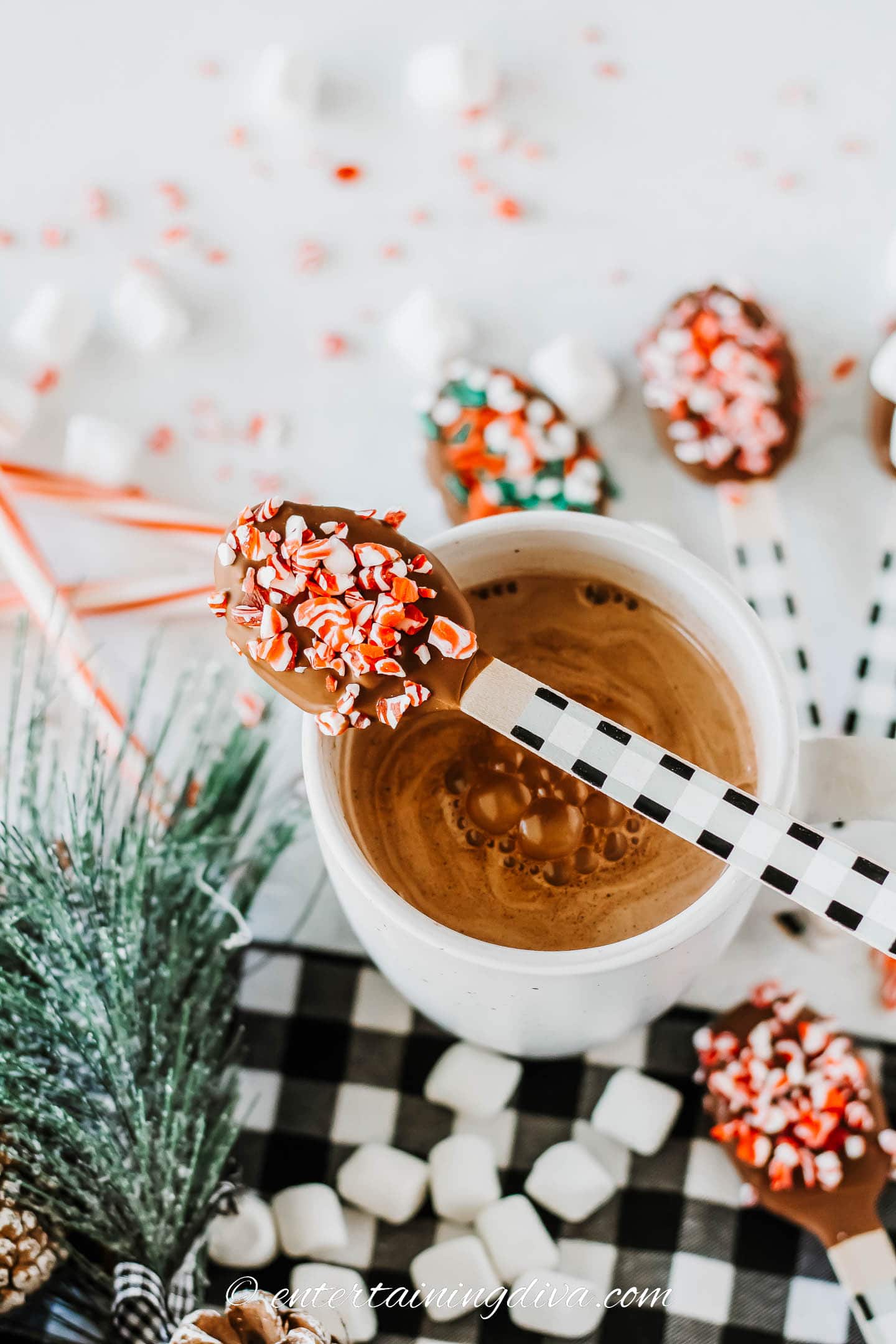 DIY hot chocolate spoon on top of a cup of hot cocoa with other dunking spoons in the background