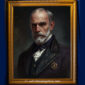 Portrait of a balding Victorian man with a pointed stare, wearing a deep red embroidered coat and cravat, set against a vintage backdrop.