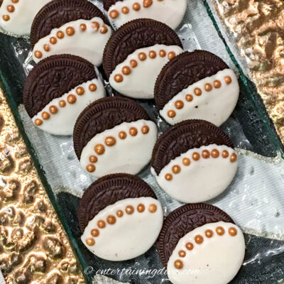 white chocolate covered Oreos with gold sugar ball trim