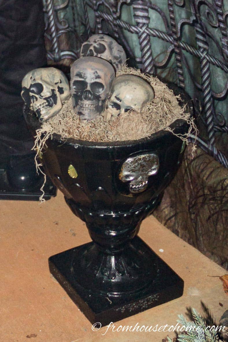 Black Halloween planter filled with plastic skulls and Spanish moss