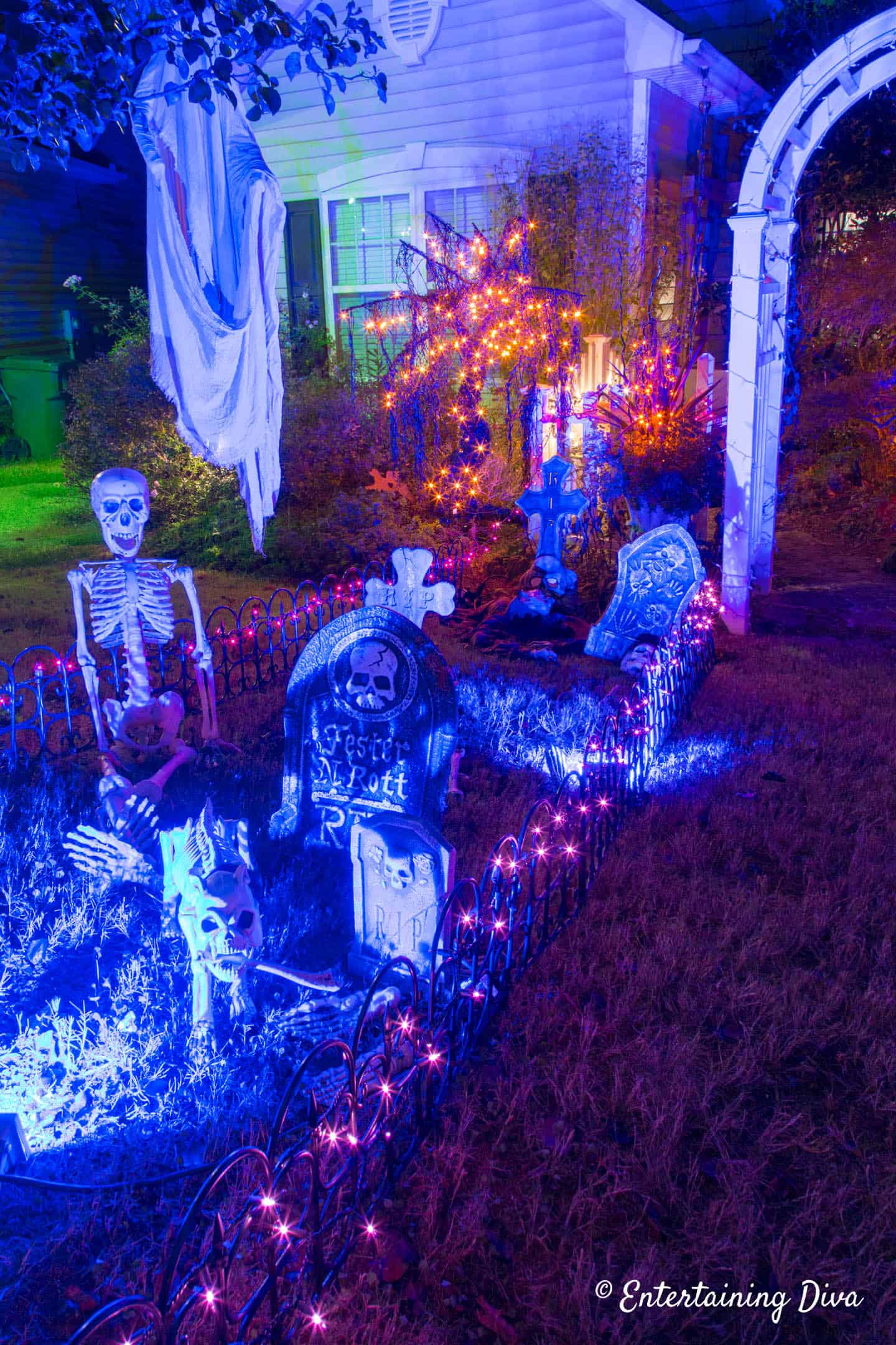 Halloween graveyard outlined by garden edging with lights