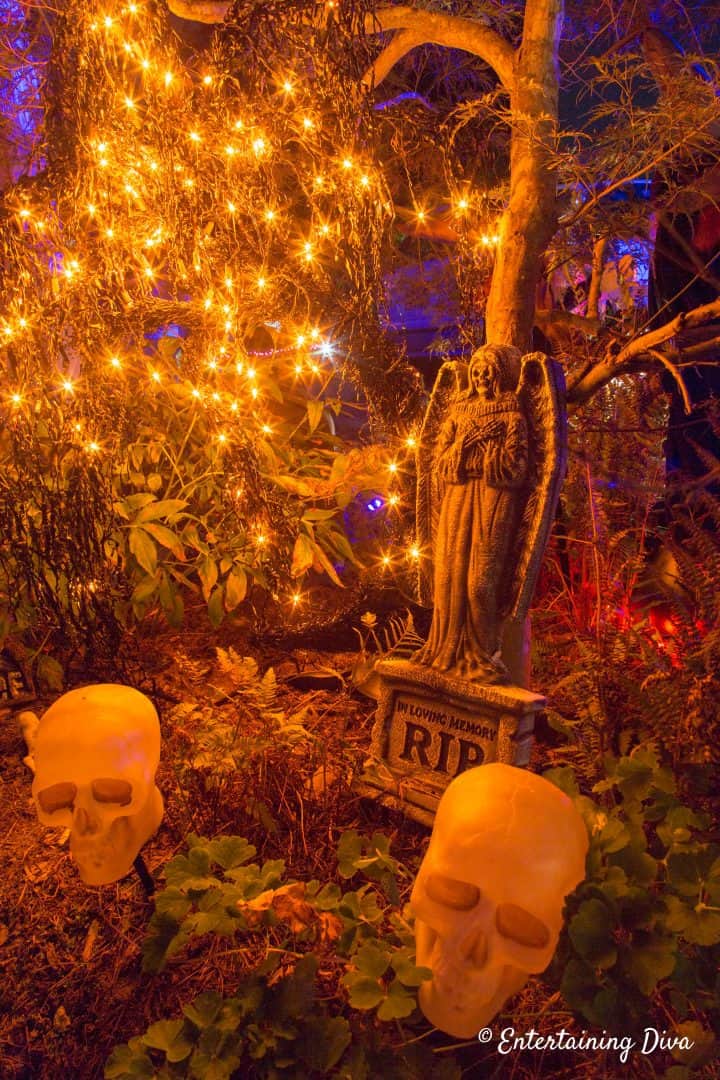 Halloween graveyard with orange string lights with skulls and a Halloween gravestone
