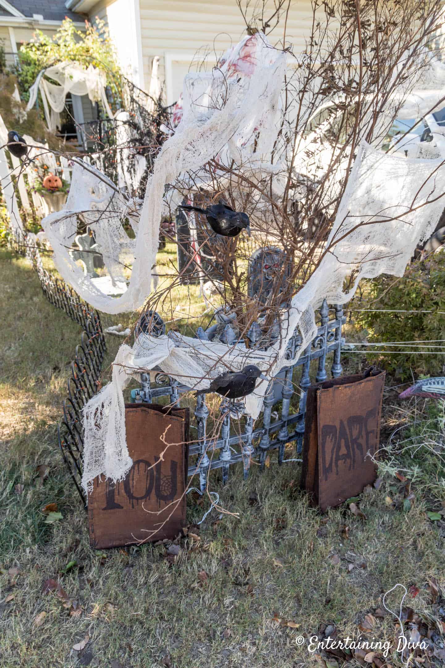 Creepy cloth and stuffed crows in some dead branches at the corner of a Halloween cemetery