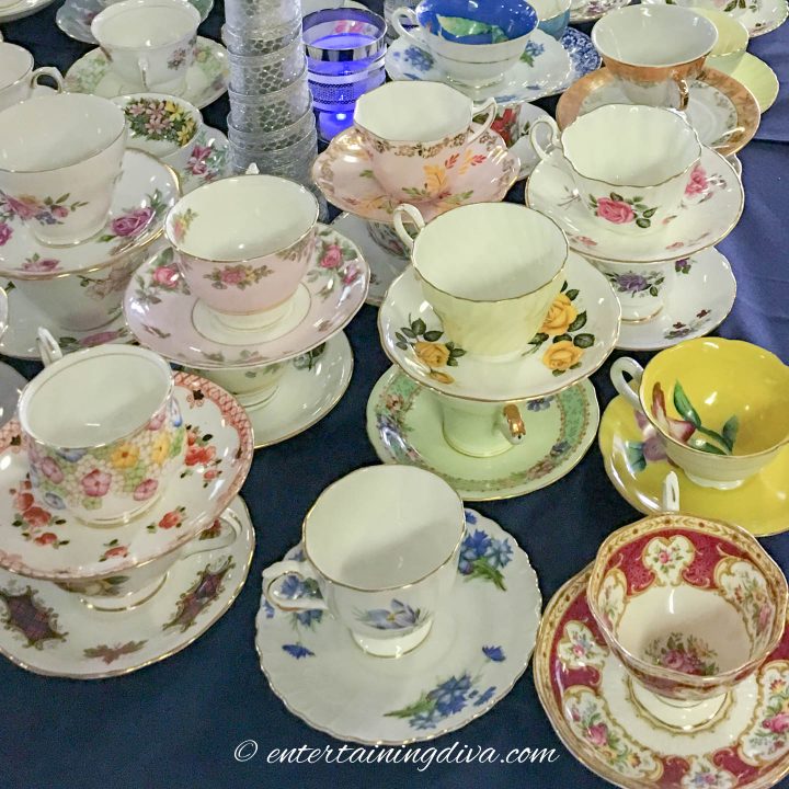 A table full of mixed and matched tea cups and saucers