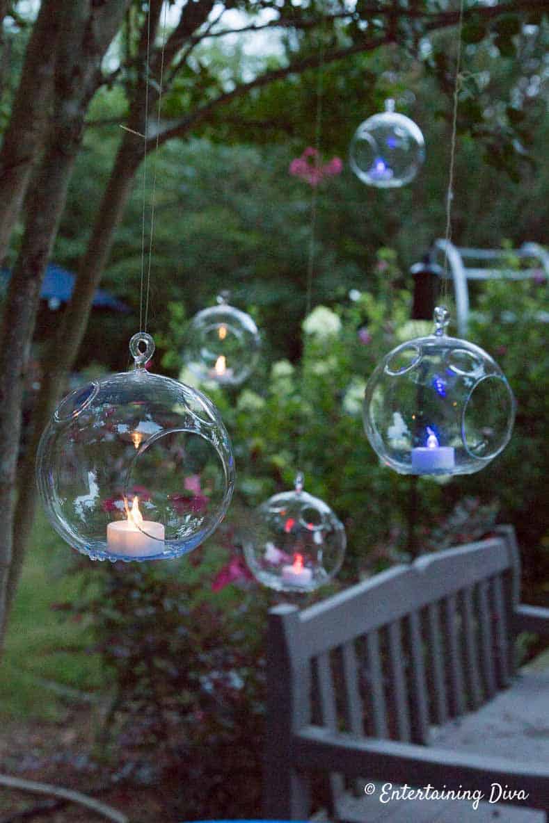 Red, white and blue flameless tealights hanging from tree are an Easy 4th of July Outdoor Decorating Idea