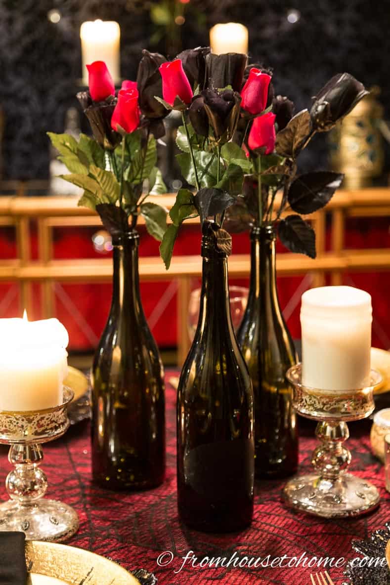 Phantom of the Opera party centerpiece made with fake black and red roses in black wine bottles