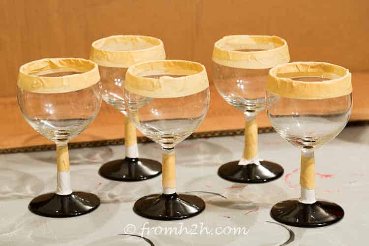 Tape the top of the glass and cover the stem | DIY Santa Wine Glasses