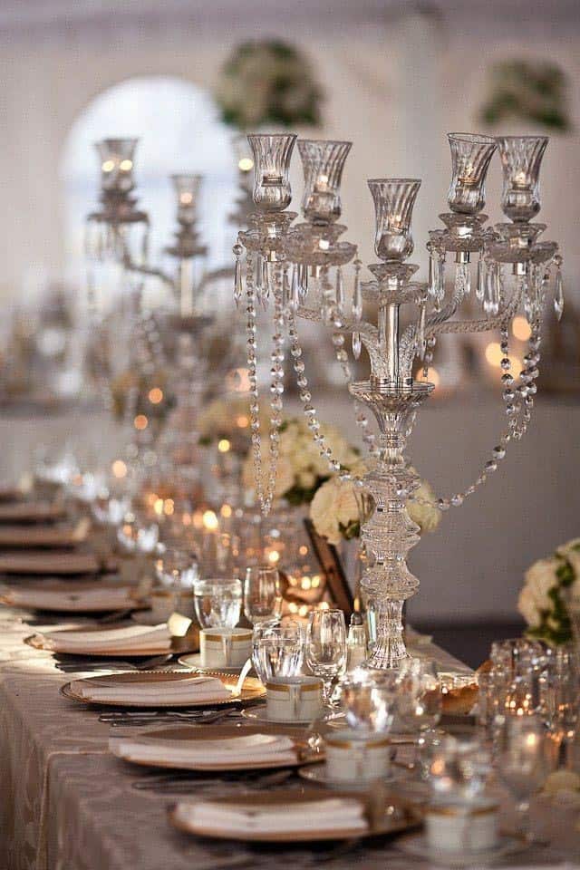 Gatsby party centerpiece with crystal candelabras and white roses in vases from blog.hotchocolates.co.uk