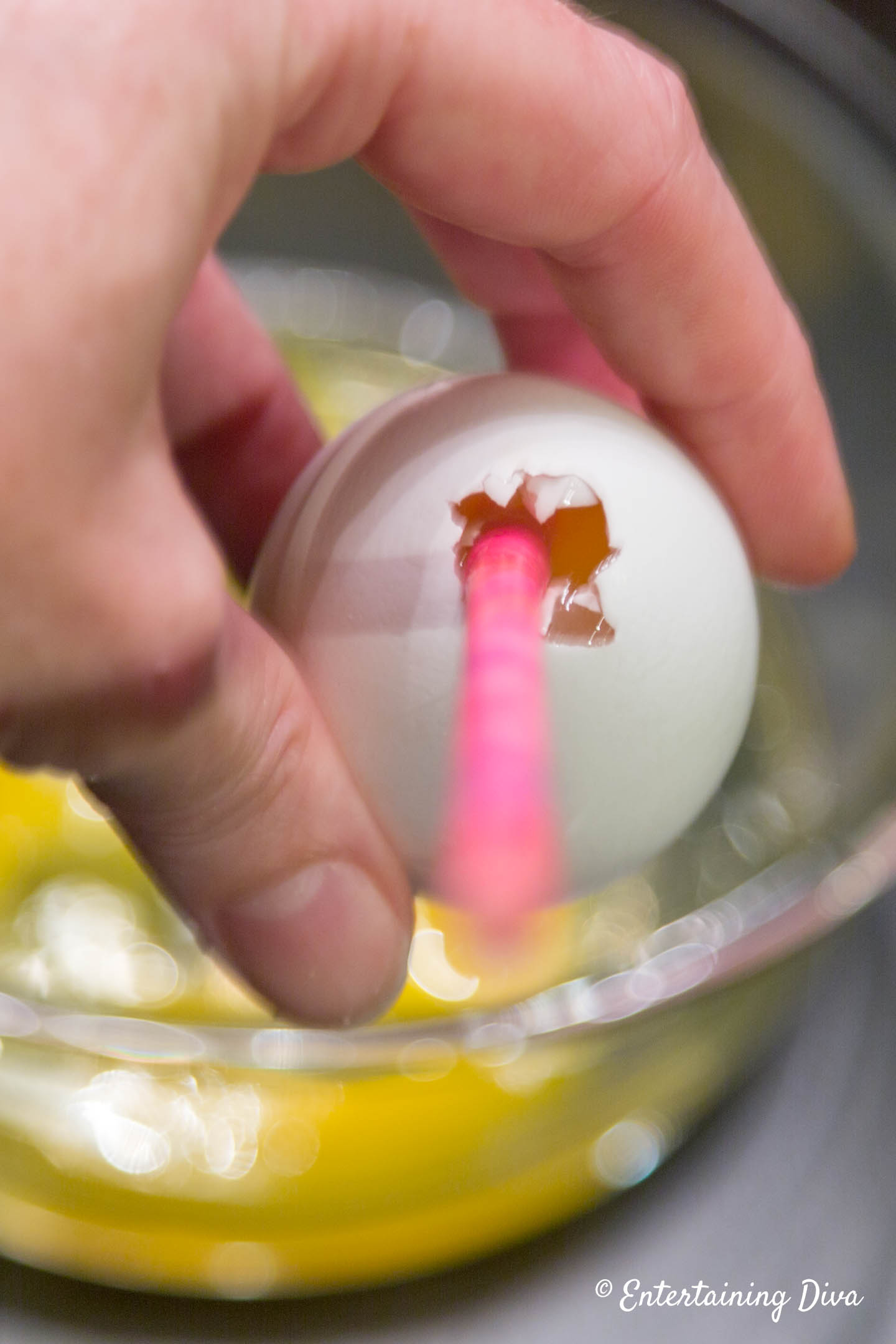 A straw in a hole at the top of an egg
