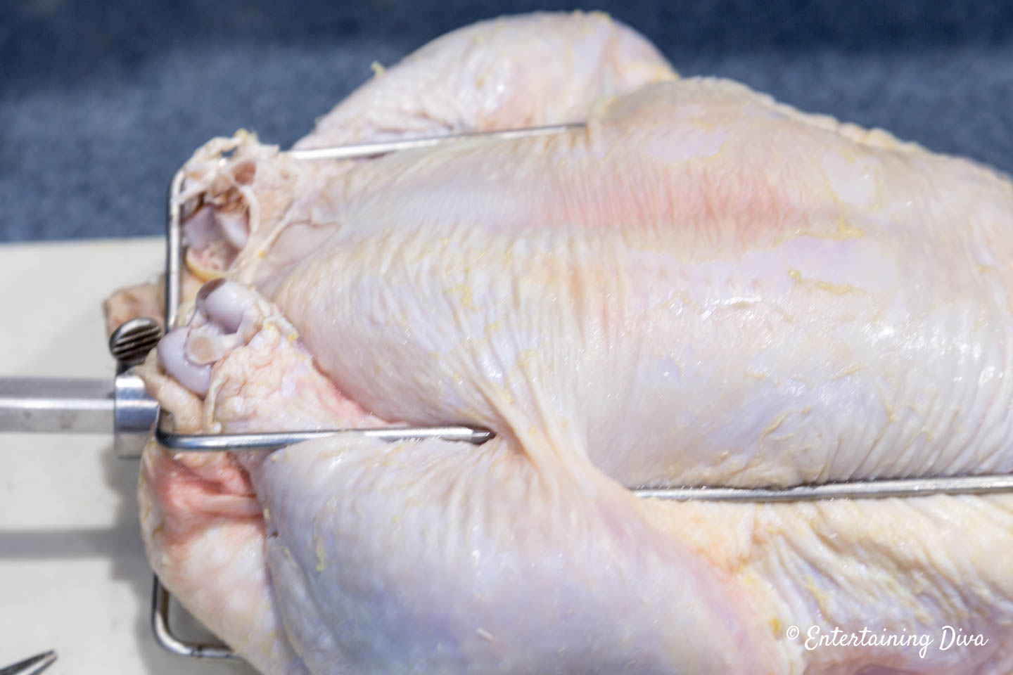 Chicken legs being held by rotisserie spit