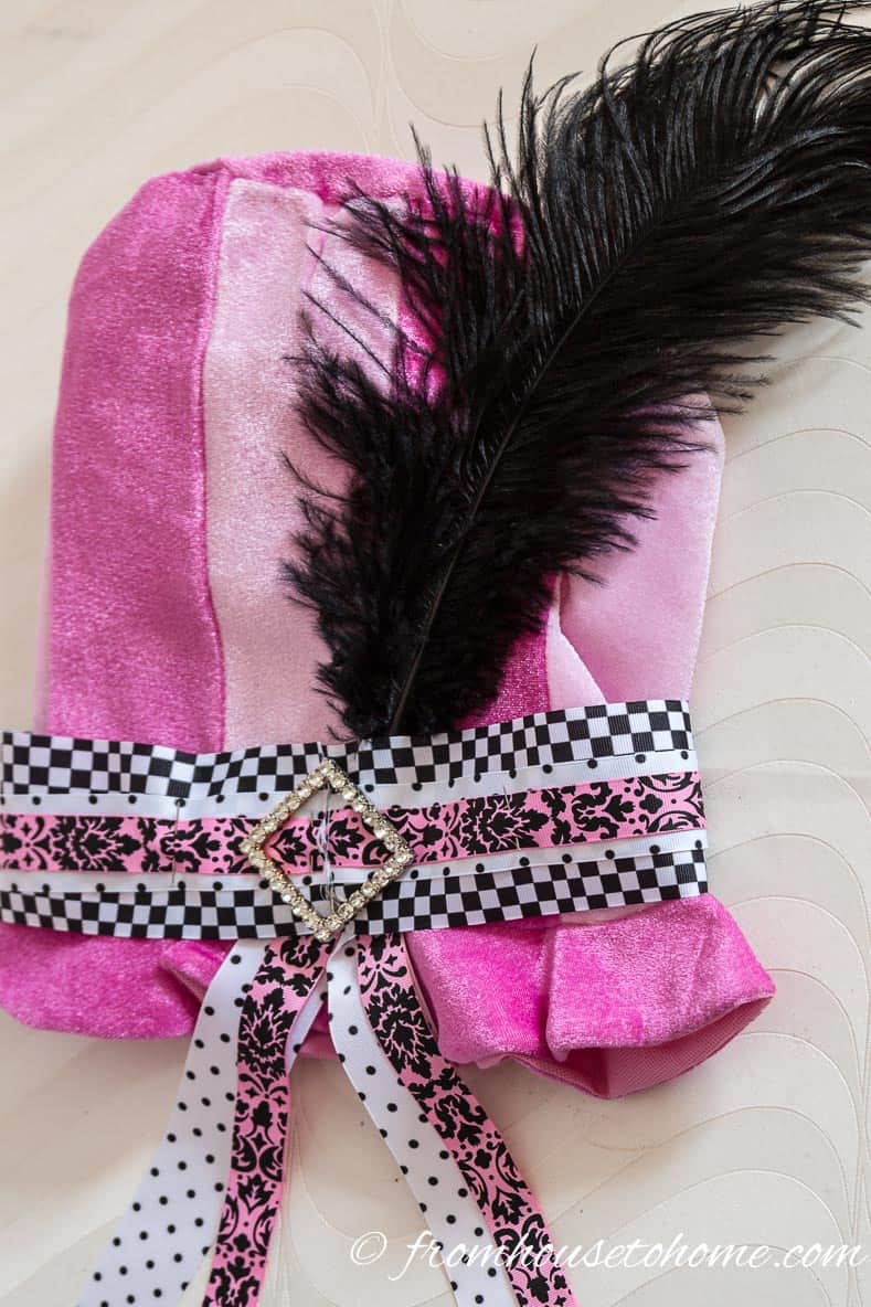Add feathers behind the ribbon using the back of the sash pin to hold them