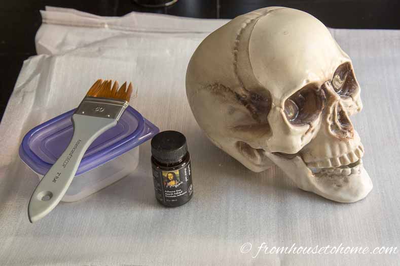 Brush with a container, a bottle of leaf adhesive and a plastic skull