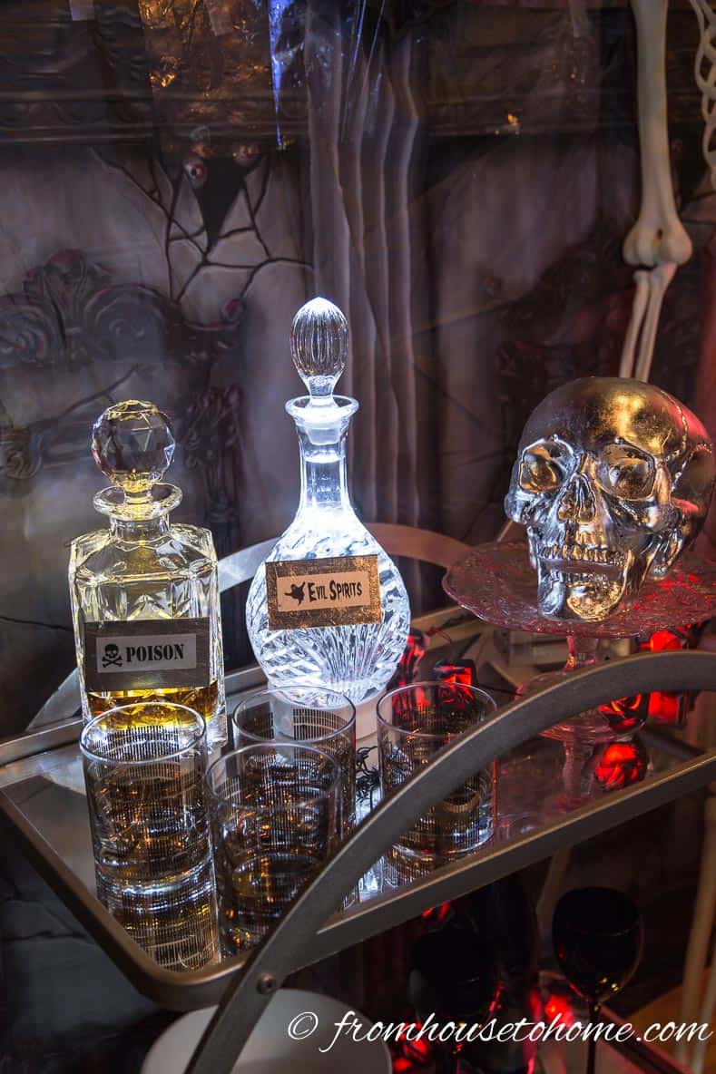 Halloween bottles with labels on bar cart with silver leaf skull