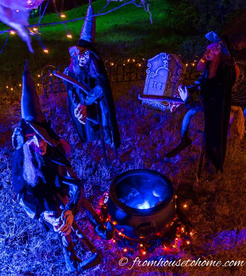 Halloween yard display with witches and boiling cauldron