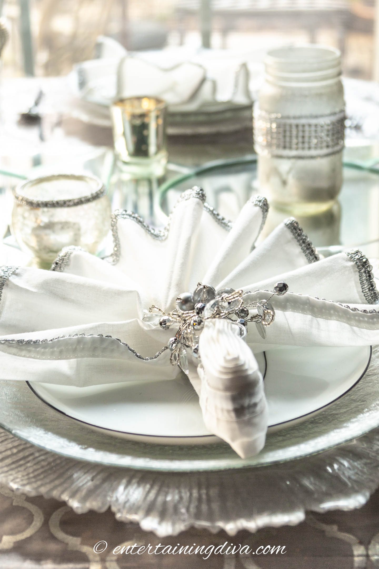 White napkins with silver edging and silver snowflake napkin rings | Silver and White Winter Table Setting