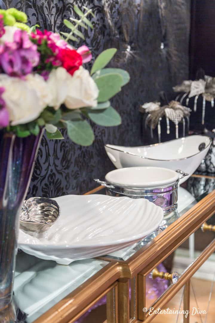 White serving dishes on a mirror buffet for a holiday dinner party